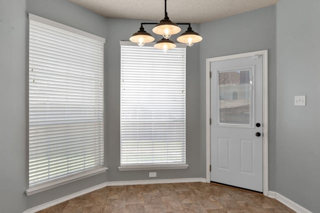 4504 Angelina Way, Fort Worth, TX 76137 - unfurnished dining area featuring a chandelier, baseboards, and a textured ceiling
