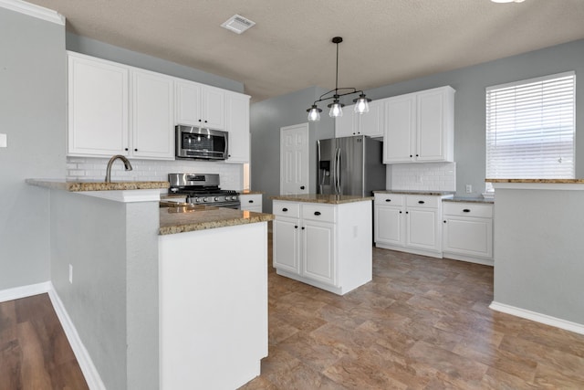 4504 Angelina Way, Fort Worth, TX 76137 - kitchen featuring appliances with stainless steel finishes, tasteful backsplash, baseboards, white cabinetry, and a peninsula