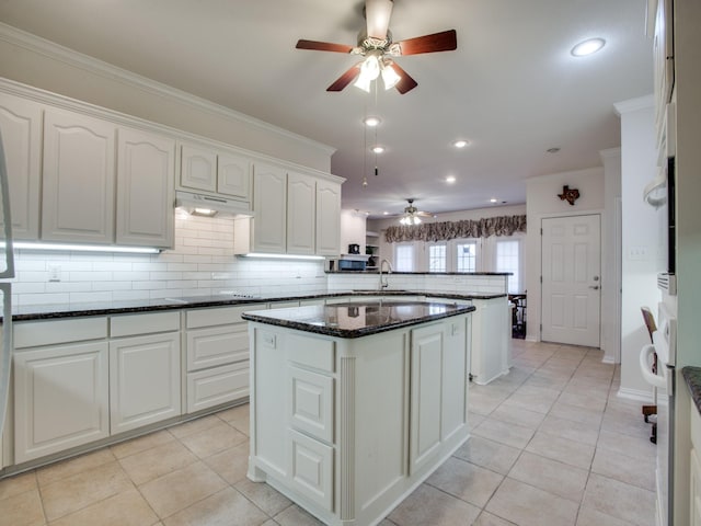 503 Hillcrest Ln, Krum, TX 76249 - kitchen featuring ceiling fan, a peninsula, under cabinet range hood, ornamental molding, and decorative backsplash