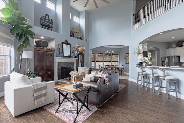 1217 Waterford Way, Allen, TX 75013 - living room with arched walkways, a ceiling fan, dark wood-type flooring, a towering ceiling, and baseboards