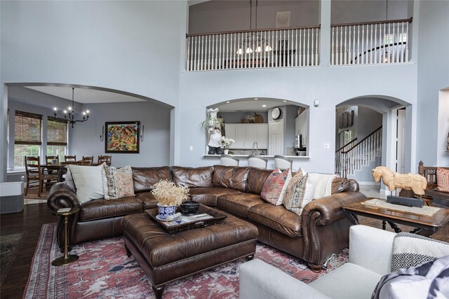 1217 Waterford Way, Allen, TX 75013 - living area featuring a chandelier, arched walkways, wood finished floors, a high ceiling, and stairway