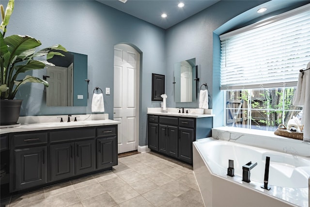 1217 Waterford Way, Allen, TX 75013 - full bathroom featuring two vanities, a bath, a textured wall, and recessed lighting