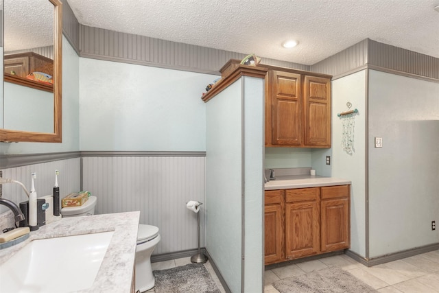 5295 Ganzer Rd W, Krum, TX 76249 - bathroom with a textured ceiling, toilet, tile patterned floors, and vanity
