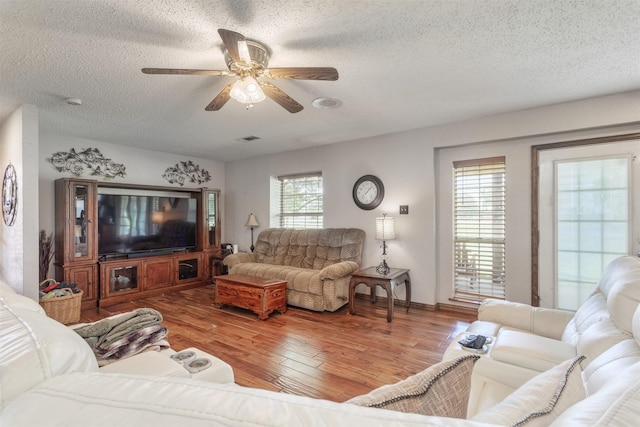 5295 Ganzer Rd W, Krum, TX 76249 - living room featuring a textured ceiling, a ceiling fan, and wood finished floors