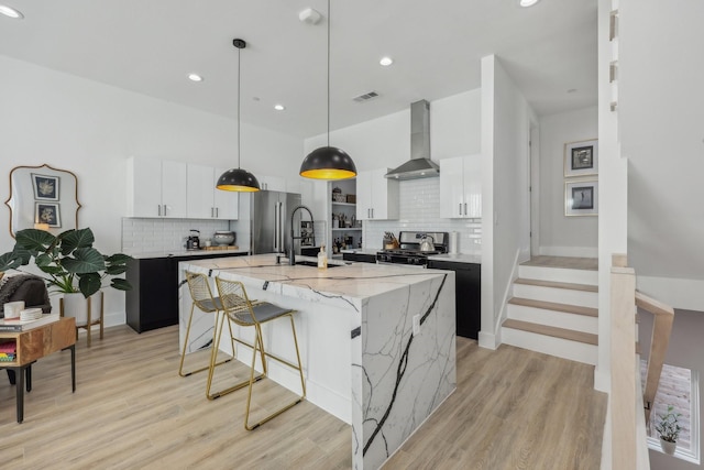2102 N Prairie Ave Unit 105, Dallas, TX 75204 - kitchen featuring wall chimney range hood, stainless steel appliances, a sink, tasteful backsplash, and recessed lighting