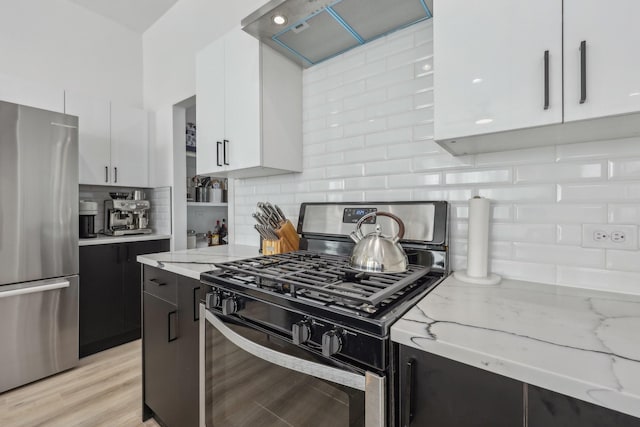 2102 N Prairie Ave Unit 105, Dallas, TX 75204 - kitchen with stainless steel appliances, wall chimney range hood, white cabinetry, backsplash, and dark cabinetry