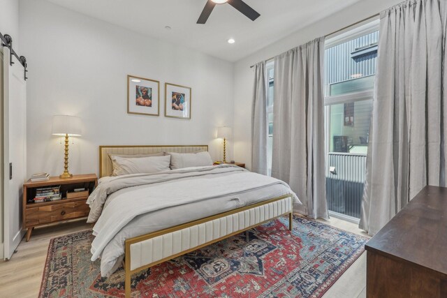 2102 N Prairie Ave Unit 105, Dallas, TX 75204 - bedroom featuring light wood-type flooring, access to outside, recessed lighting, a barn door, and ceiling fan