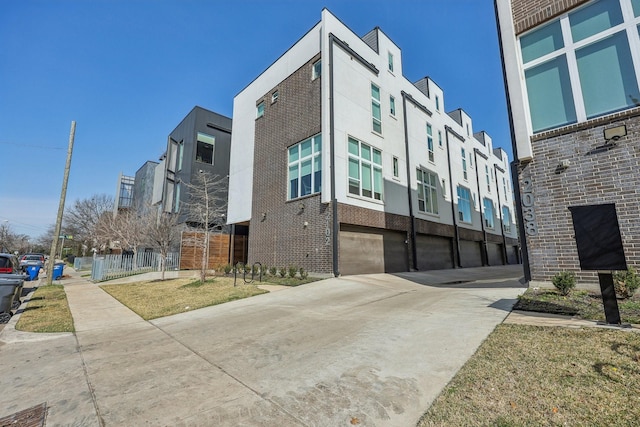 2102 N Prairie Ave Unit 105, Dallas, TX 75204 - view of building exterior featuring concrete driveway and a garage