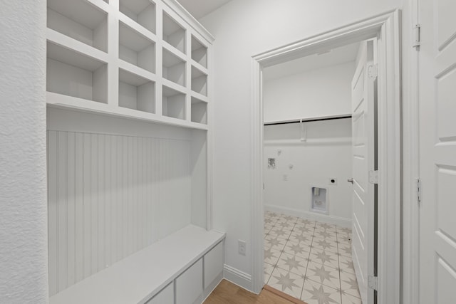 mudroom featuring light floors and baseboards