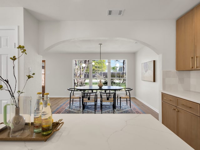 618 Berkley Dr, Grapevine, TX 76051 - dining area featuring arched walkways, wood finished floors, and baseboards