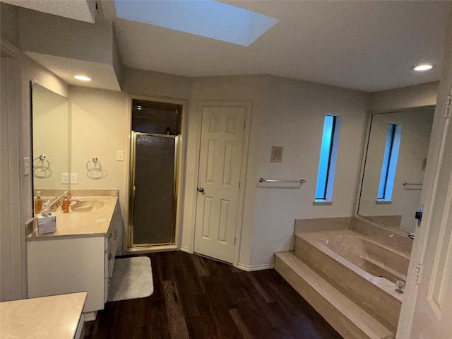 4809 Westhaven Rd, Arlington, TX 76017 - bathroom with wood finished floors, a shower stall, vanity, a skylight, and a garden tub