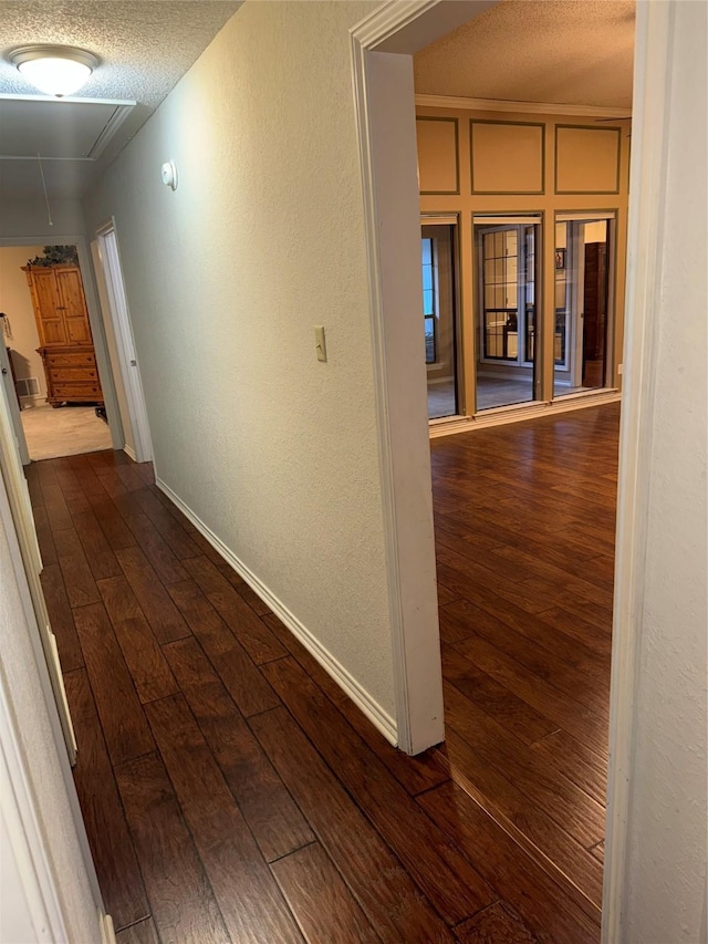 4809 Westhaven Rd, Arlington, TX 76017 - hallway featuring attic access, dark wood-type flooring, baseboards, a textured wall, and a textured ceiling