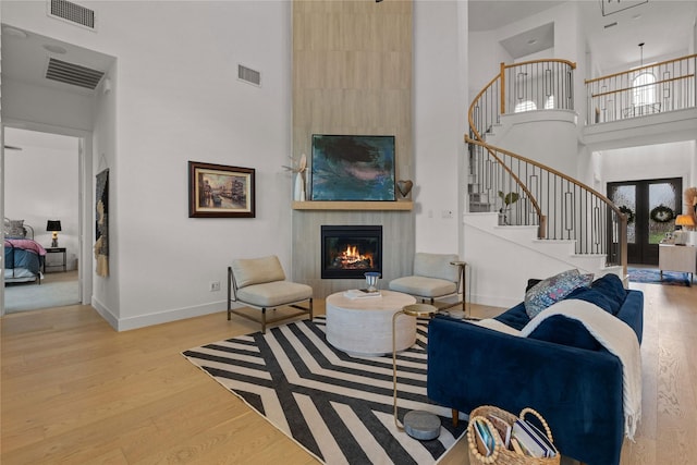 507 Melody Meadow Dr, Rockwall, TX 75087 - living area with a towering ceiling, wood finished floors, stairway, and a tiled fireplace