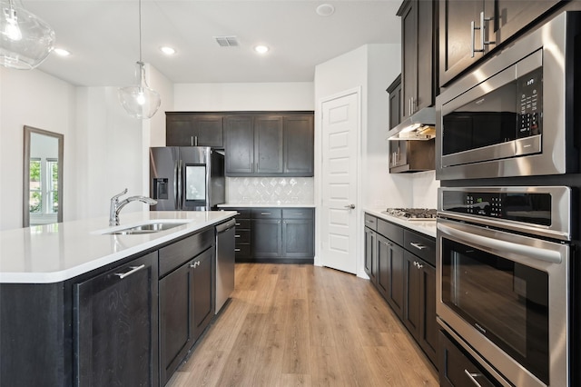 6322 Farndon Dr, Celina, TX 76227 - kitchen with stainless steel appliances, light countertops, light wood finished floors, pendant lighting, and backsplash