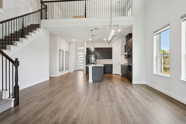 6322 Farndon Dr, Celina, TX 76227 - unfurnished living room with a high ceiling, stairs, wood finished floors, and recessed lighting