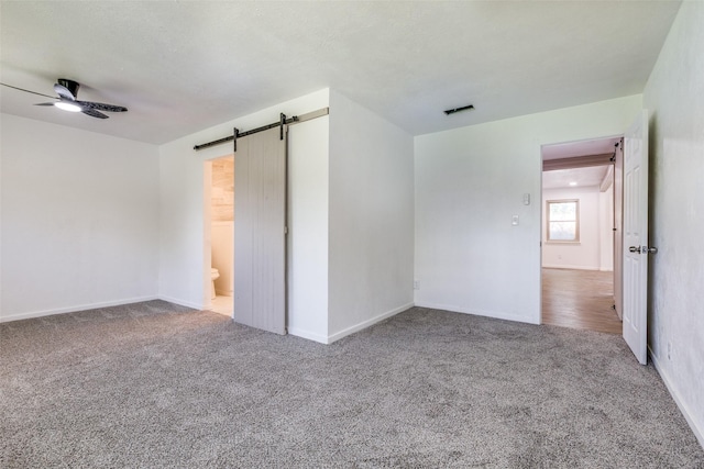 5241 E Berry St, Fort Worth, TX 76119 - unfurnished bedroom with carpet, a barn door, baseboards, and ensuite bathroom