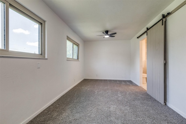5241 E Berry St, Fort Worth, TX 76119 - carpeted empty room with a barn door, a ceiling fan, and baseboards
