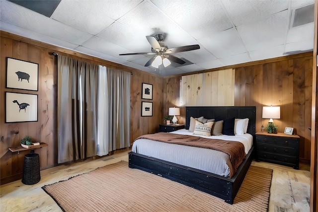 442 W Mccart St, Krum, TX 76249 - bedroom featuring light wood-type flooring, wooden walls, a ceiling fan, and baseboards
