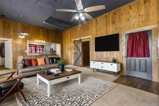 442 W Mccart St, Krum, TX 76249 - living area with wooden walls, a ceiling fan, a barn door, and wood finished floors
