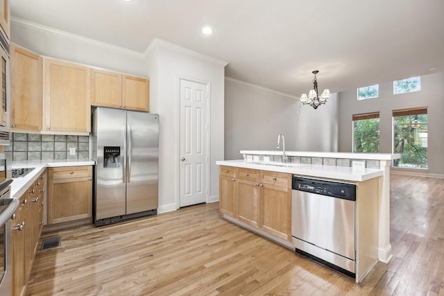 2028 N Haskell Ave, Dallas, TX 75204 - kitchen featuring stainless steel appliances, light brown cabinetry, a sink, light wood-style flooring, and a chandelier