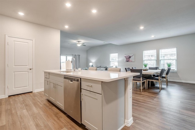 2148 Bellatrix Dr, Haslet, TX 76052 - kitchen with stainless steel dishwasher, a sink, open floor plan, light countertops, and light wood-style floors