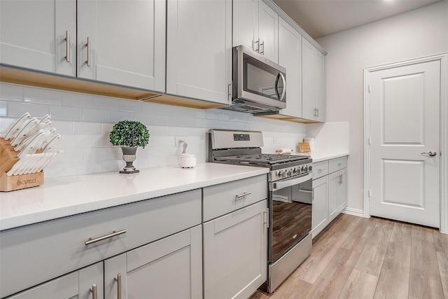 2148 Bellatrix Dr, Haslet, TX 76052 - kitchen with stainless steel appliances, backsplash, light countertops, and gray cabinets