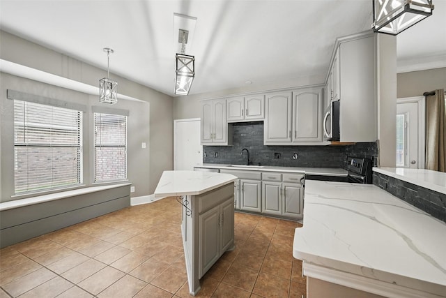 3211 Ruidoso Ln, Mckinney, TX 75070 - kitchen with stainless steel microwave, decorative backsplash, tile patterned floors, electric range, and decorative light fixtures