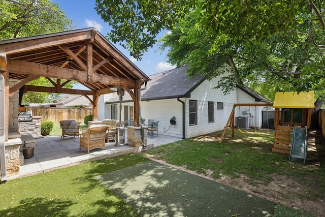 569 Dove Creek Cir, Grapevine, TX 76051 - back of property with a playground, central air condition unit, a gazebo, an outdoor kitchen, and a patio area