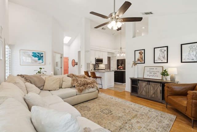 569 Dove Creek Cir, Grapevine, TX 76051 - living room featuring vaulted ceiling, light wood-style floors, a stone fireplace, healthy amount of natural light, and a ceiling fan
