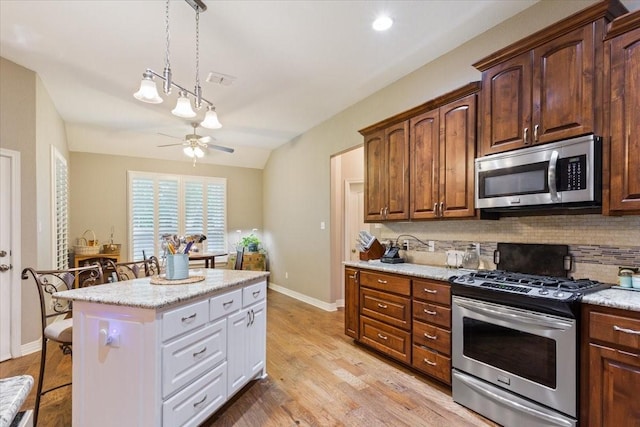 128 Creek Rdg, Waco, TX 76708 - kitchen featuring stainless steel appliances, decorative backsplash, a kitchen bar, a ceiling fan, and a kitchen island
