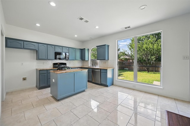 2668 Silver Hill Dr, Fort Worth, TX 76131 - kitchen with stainless steel dishwasher, gas range, backsplash, a kitchen island, and recessed lighting