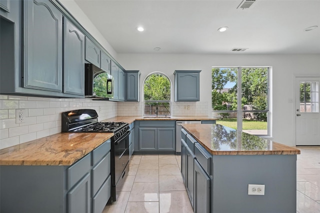 2668 Silver Hill Dr, Fort Worth, TX 76131 - kitchen with black appliances, a sink, a center island, decorative backsplash, and recessed lighting