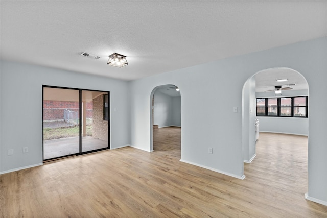 4306 Frog Dr, Killeen, TX 76542 - empty room featuring arched walkways, wood finished floors, baseboards, ceiling fan, and a textured ceiling