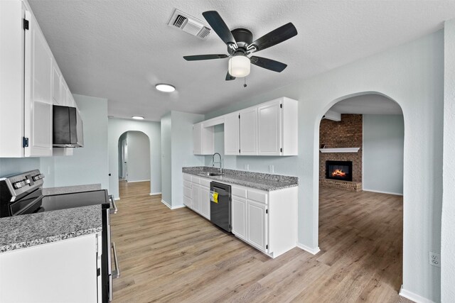 4306 Frog Dr, Killeen, TX 76542 - kitchen featuring appliances with stainless steel finishes, arched walkways, a sink, light wood-style flooring, and a textured ceiling