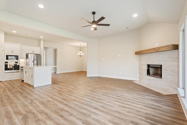 514 Geyser Trl, Waco, TX 76657 - unfurnished living room with a tile fireplace, light wood finished floors, ceiling fan, a chandelier, and recessed lighting
