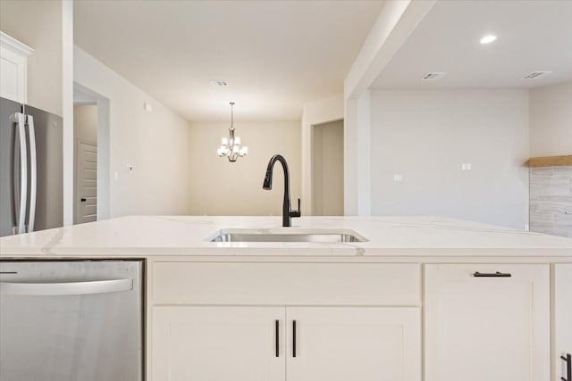 514 Geyser Trl, Waco, TX 76657 - kitchen featuring stainless steel dishwasher, a sink, white cabinets, a chandelier, and light stone countertops
