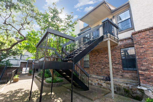 8750 Park Ln Unit 151, Dallas, TX 75231 - back of house with stairway and brick siding