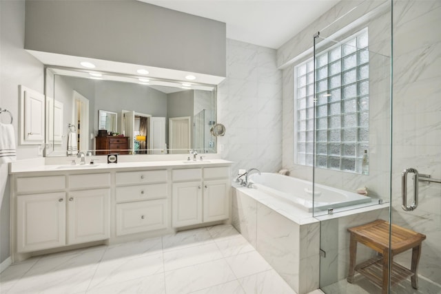 7904 Briar Brook Ct, Dallas, TX 75218 - bathroom featuring double vanity, a garden tub, marble finish flooring, a shower stall, and tile walls