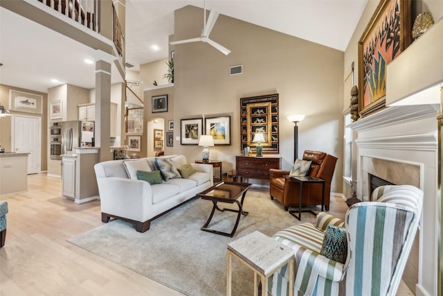 7904 Briar Brook Ct, Dallas, TX 75218 - living room with high vaulted ceiling, ceiling fan, a high end fireplace, light wood-type flooring, and baseboards
