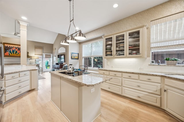 7904 Briar Brook Ct, Dallas, TX 75218 - kitchen featuring black electric stovetop, tasteful backsplash, a kitchen island, glass insert cabinets, and light stone countertops