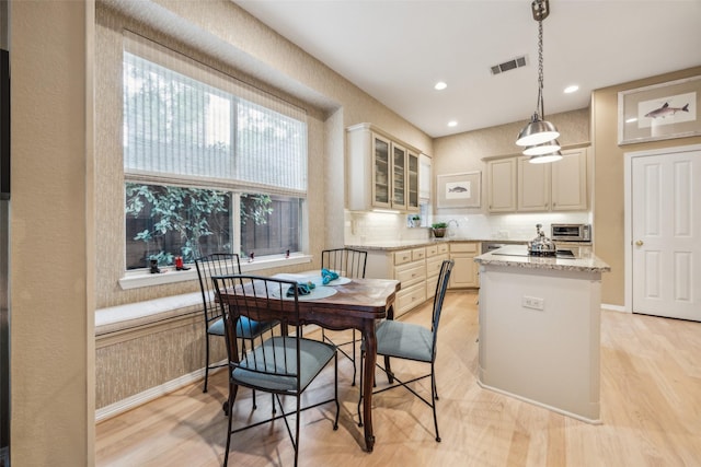 7904 Briar Brook Ct, Dallas, TX 75218 - kitchen with a center island, glass insert cabinets, light wood-type flooring, a sink, and recessed lighting