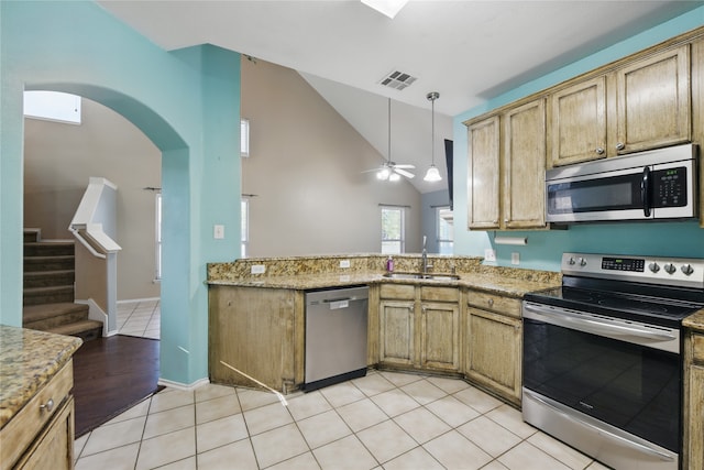 1632 Degnen Ln, Providence Village, TX 76227 - kitchen featuring stainless steel appliances, a sink, ceiling fan, arched walkways, and light stone countertops