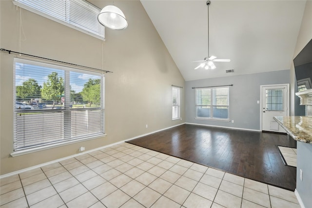1632 Degnen Ln, Providence Village, TX 76227 - unfurnished living room with high vaulted ceiling, ceiling fan, wood finished floors, and baseboards