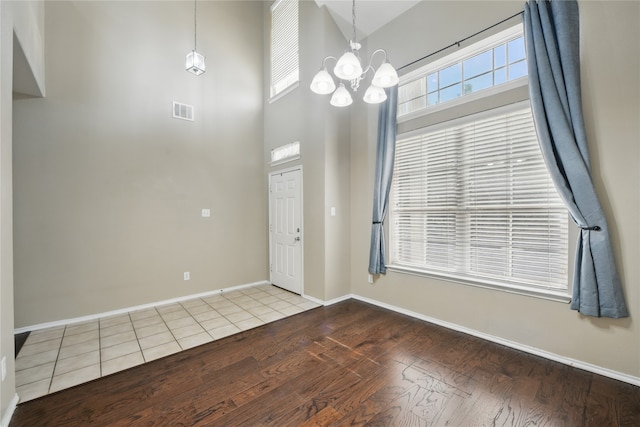 1632 Degnen Ln, Providence Village, TX 76227 - entryway featuring wood finished floors, a chandelier, plenty of natural light, baseboards, and a towering ceiling