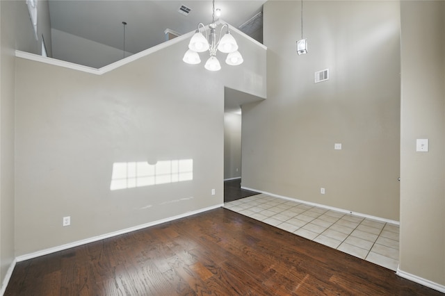 1632 Degnen Ln, Providence Village, TX 76227 - unfurnished room with a chandelier, a towering ceiling, wood finished floors, and baseboards