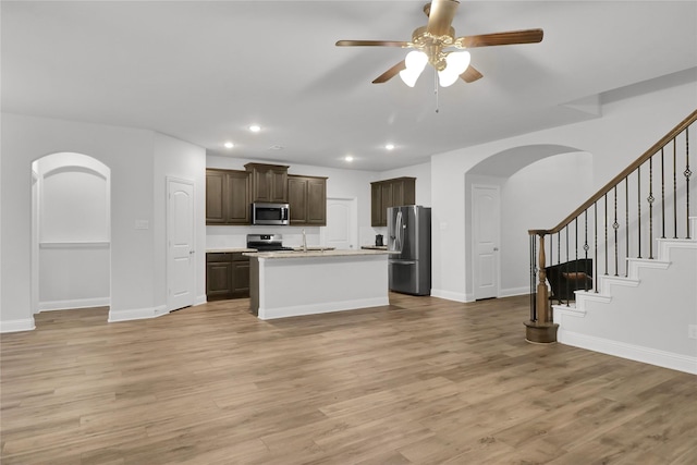 2917 Bobcat Dr, Melissa, TX 75454 - kitchen featuring appliances with stainless steel finishes, arched walkways, dark brown cabinets, light countertops, and recessed lighting
