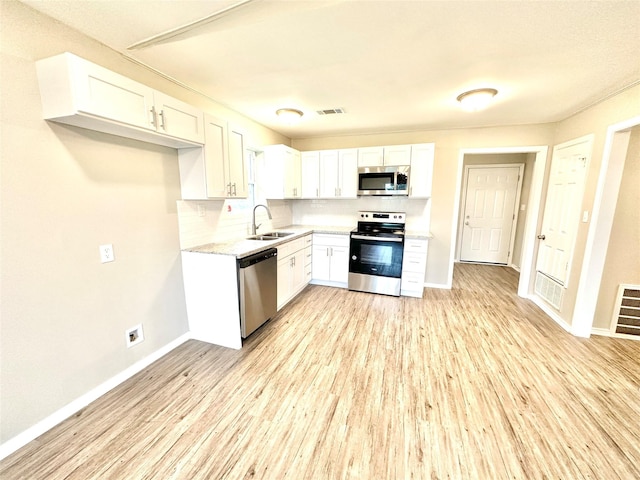 177 Catfish Trl, Whitney, TX 76692 - kitchen featuring stainless steel appliances, baseboards, a sink, light wood-style floors, and white cabinetry