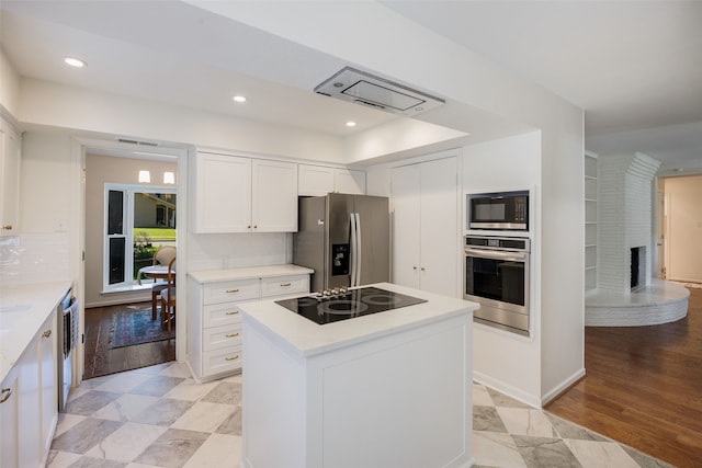 kitchen featuring black appliances, white cabinets, light countertops, a fireplace, and recessed lighting