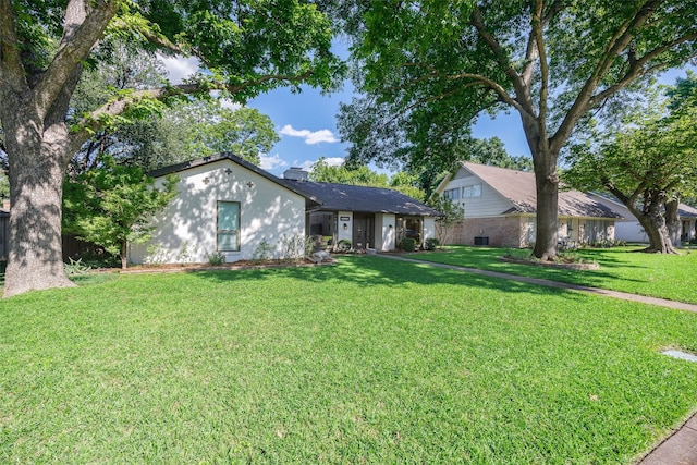 ranch-style house featuring a front lawn and a chimney