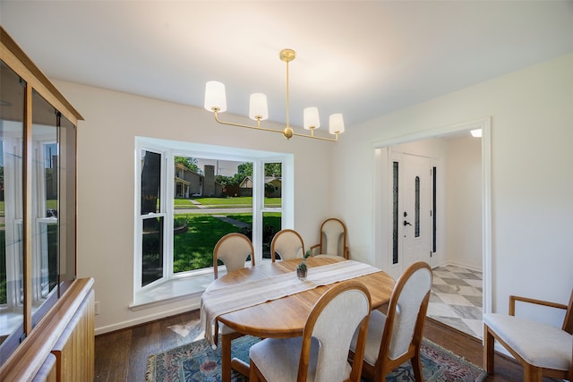 dining space with a chandelier, dark wood-type flooring, and baseboards